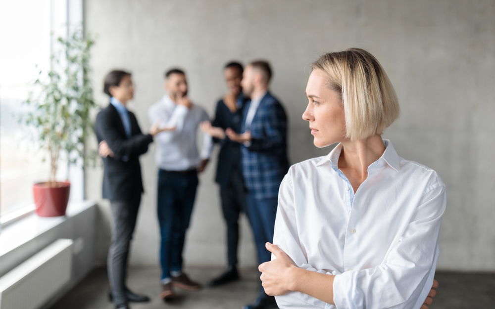 Male,Coworkers,Whispering,Behind,Back,Of,Unhappy,Businesswoman,Spreading,Rumors Bullying & Harassment